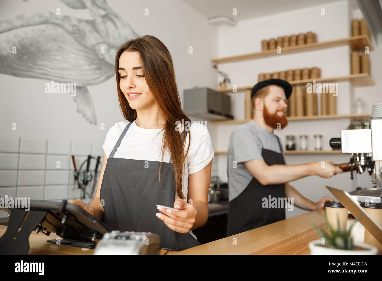 Coffee Business Concept Beautiful female barista giving payment