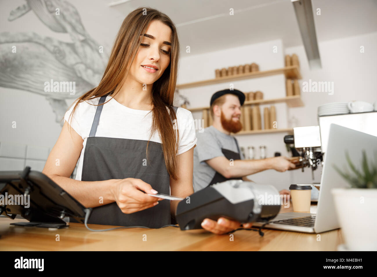 Coffee Business Concept Beautiful female barista giving payment