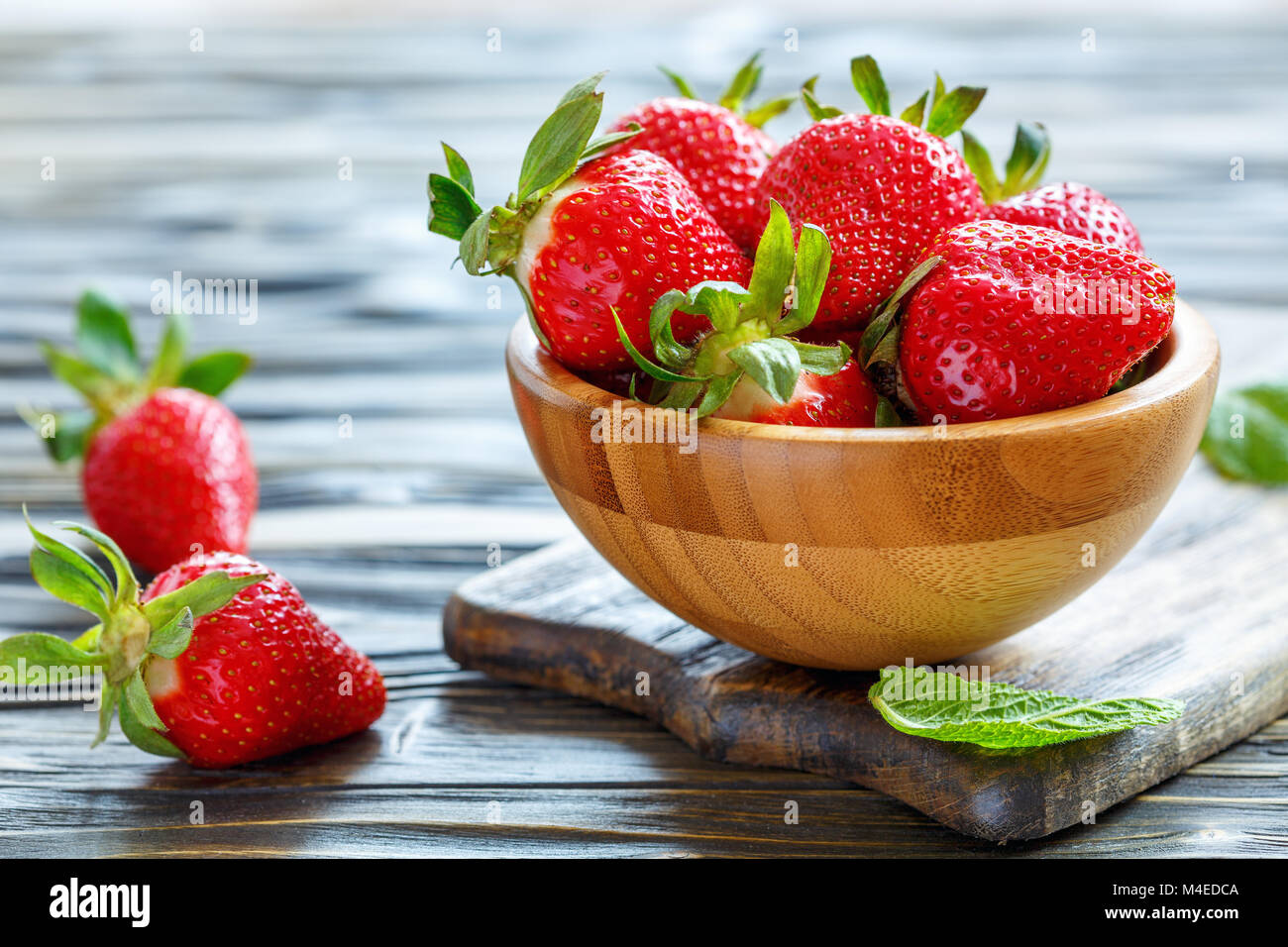 Ripe red strawberries in a wooden bowl. Stock Photo