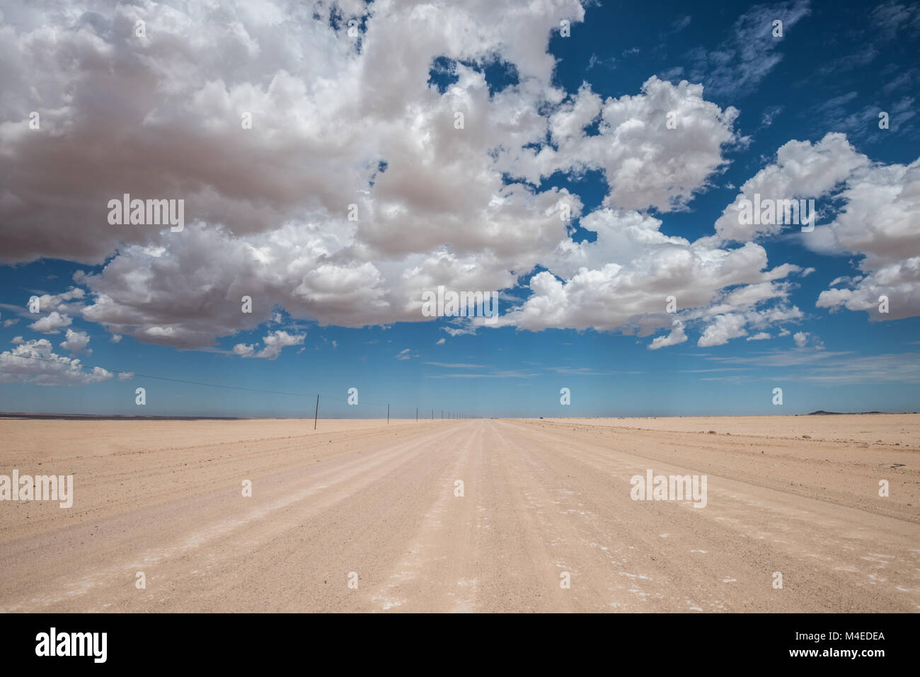 vibrant image of desert road and blue cloudy sky Stock Photo - Alamy