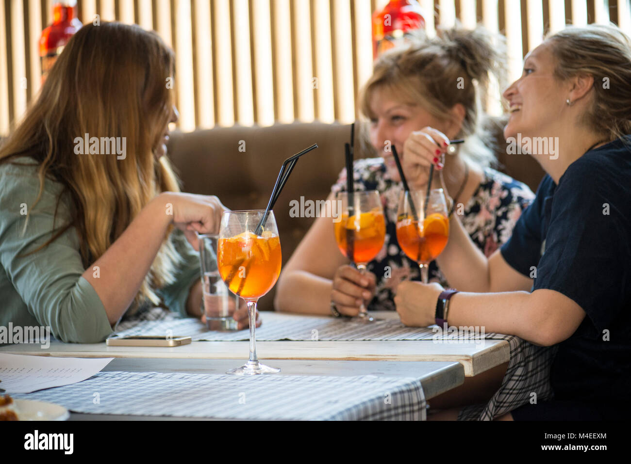 Three women drinking cocktails in a bar Stock Photo