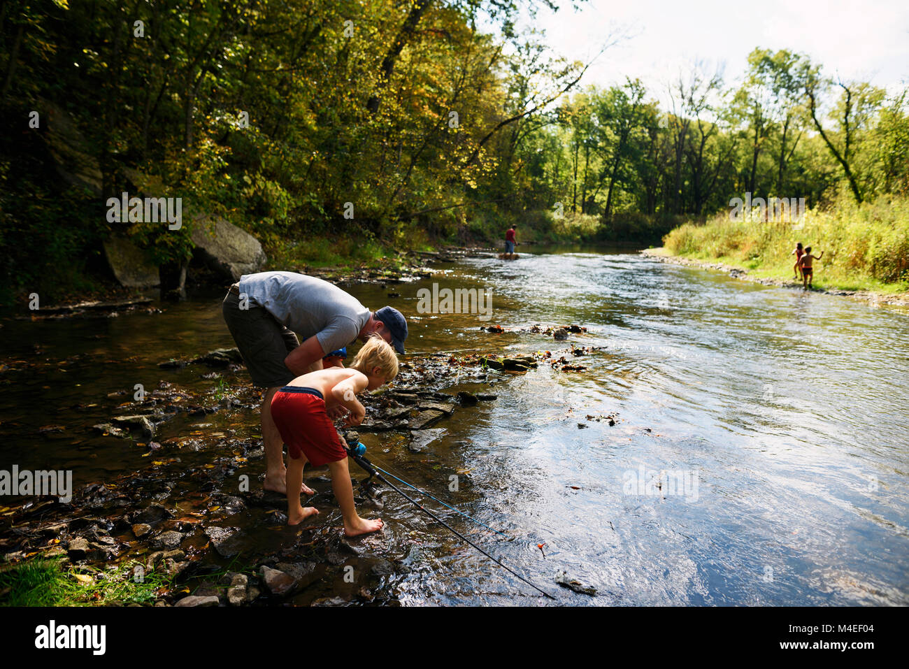Father and son fishing in river Stock Photo