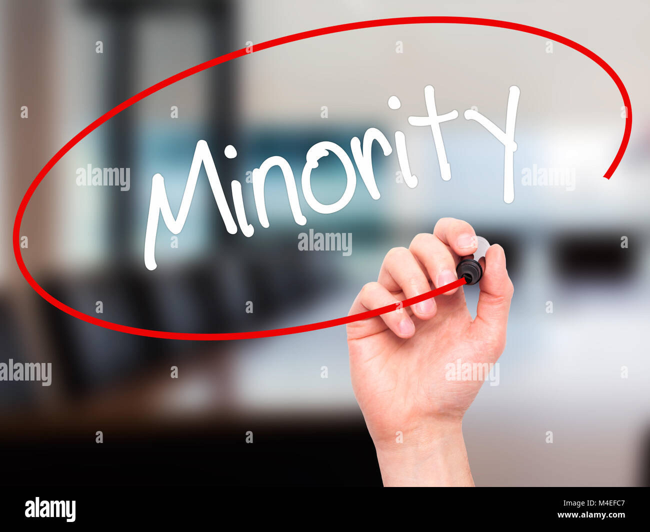 Man Hand writing Minority with black marker on visual screen Stock Photo