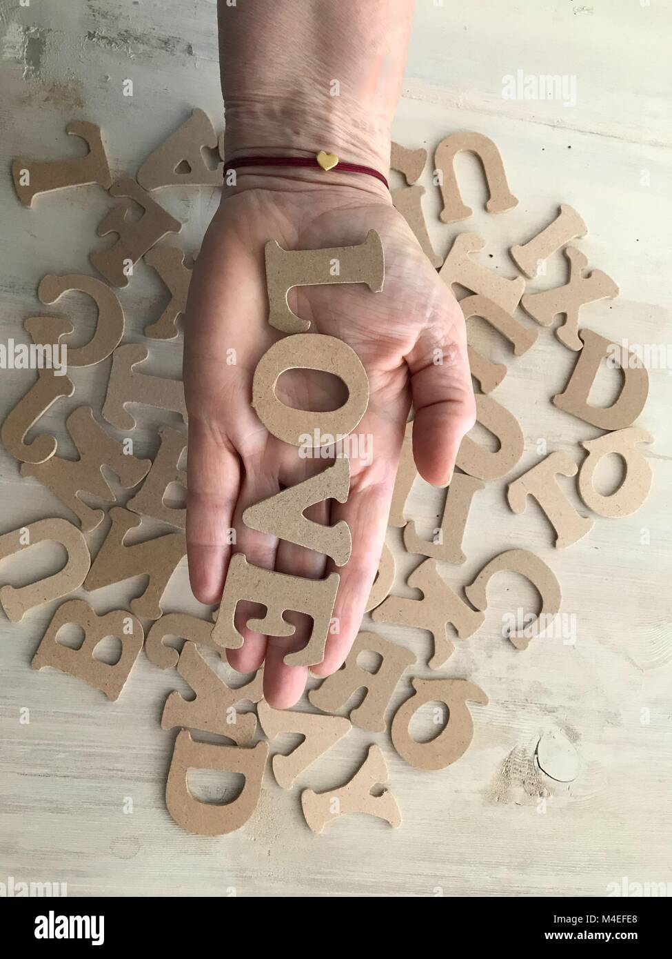 Woman's hand holding letters spelling the word love Stock Photo Alamy