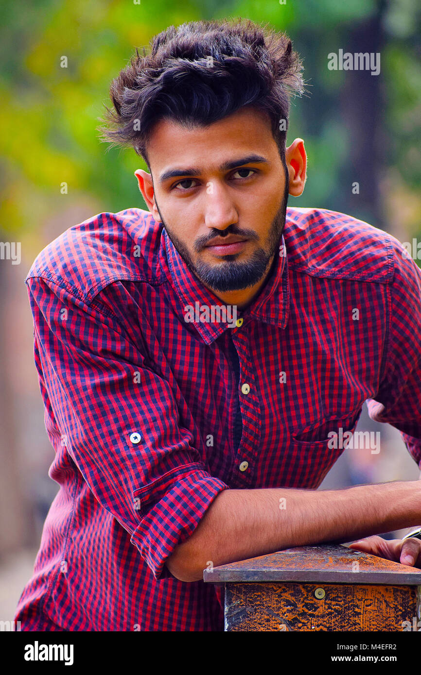 Young man with checked shirt looking at camera, Pune, Maharashtra. Stock Photo