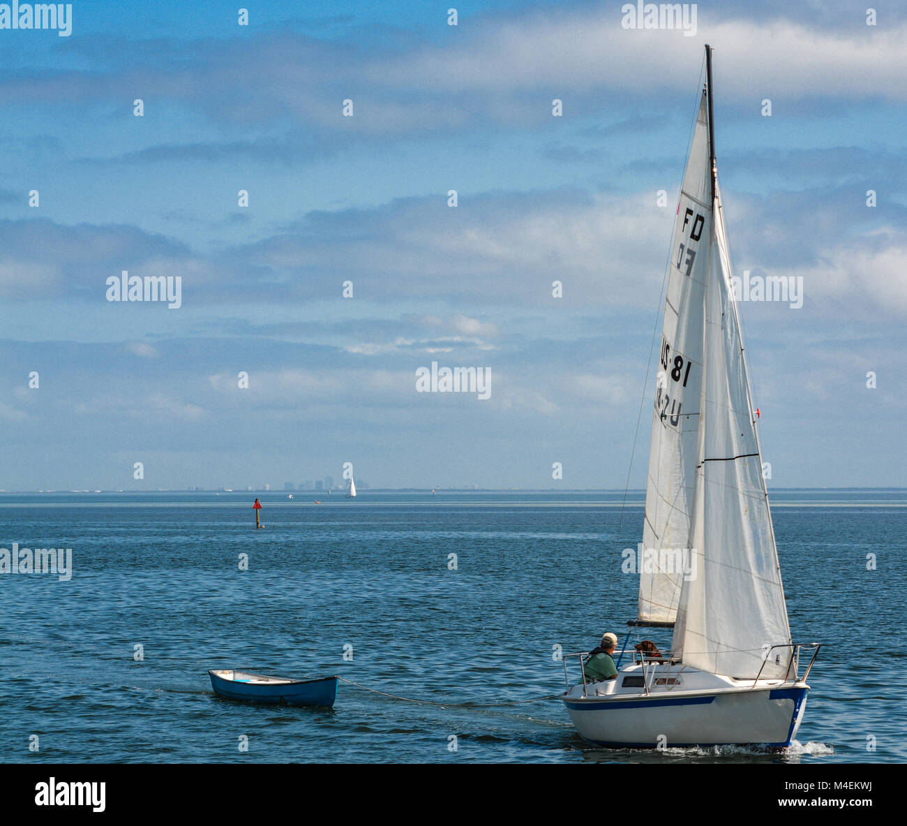 sail boat pulling a dinghy boat Stock Photo Alamy