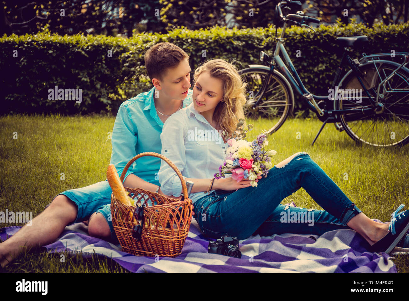 Lovely couple on picnik in a park in summer sunny day. Stock Photo