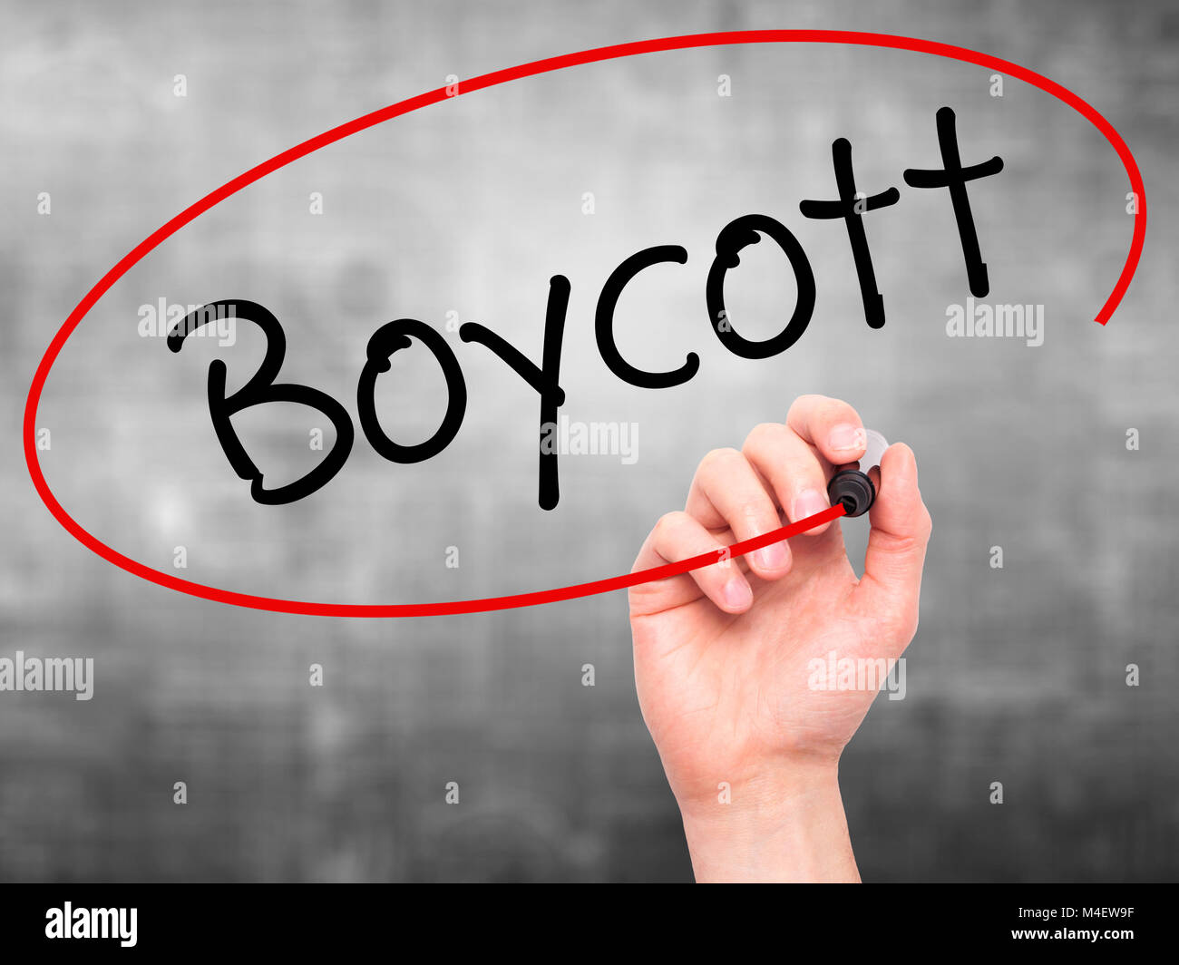Man Hand writing Boycott with black marker on visual screen. Stock Photo