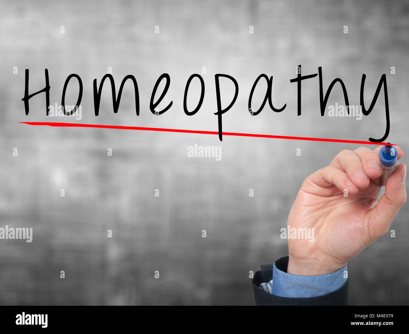 Man Hand writing Homeopathy with marker on transparent wipe board Stock Photo
