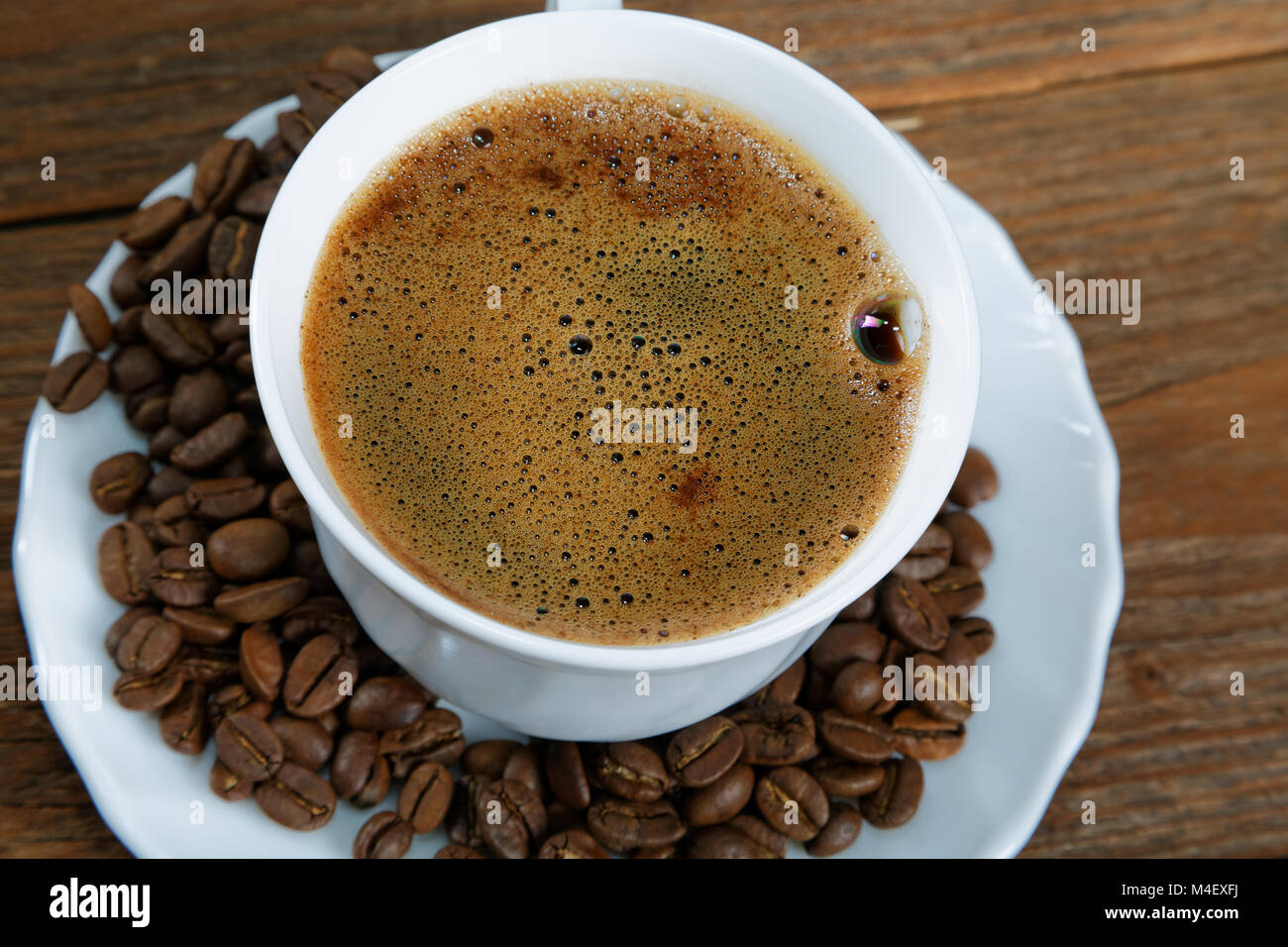 Cup with coffee on the table next to coffee beans Stock Photo