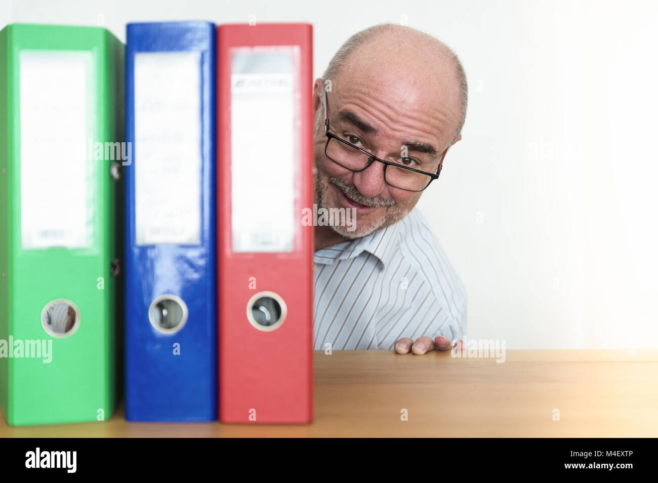 An official greeted happily behind his files. Stock Photo