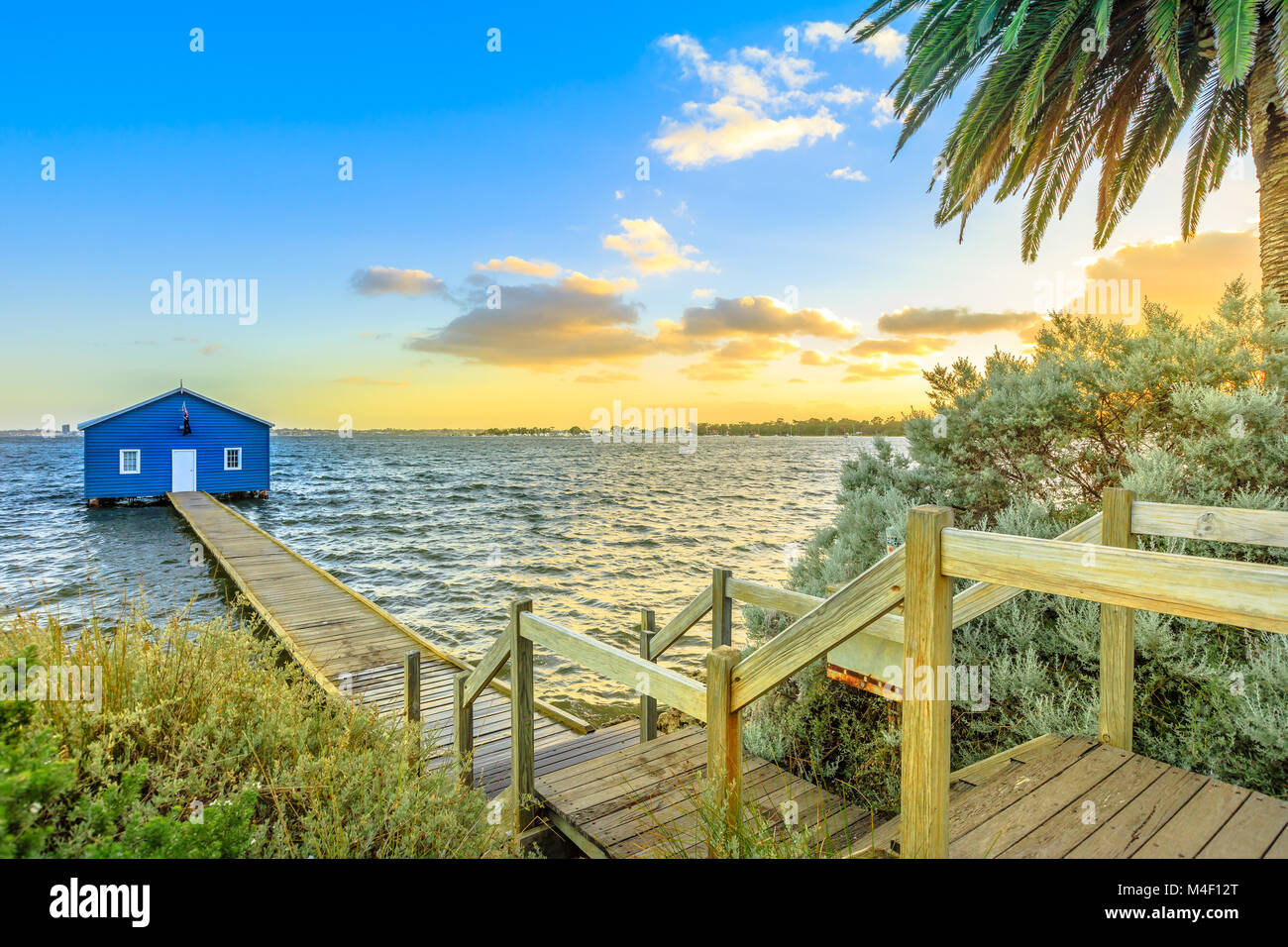 The iconic landscape of blue boat house from 1930s with wooden jetty on Swan River at sunset light. One of the most photographed locations in Perth, Western Australia, near Kings Park. Stock Photo