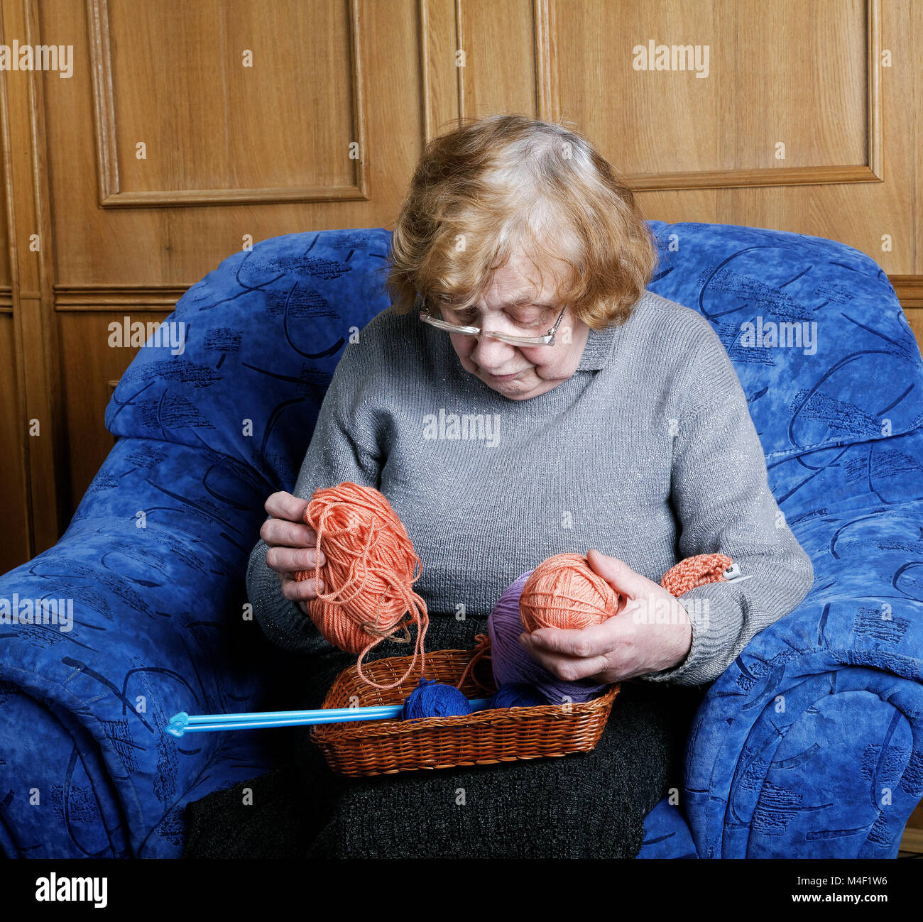 grandmother in a chair with a thread for knitting Stock Photo - Alamy