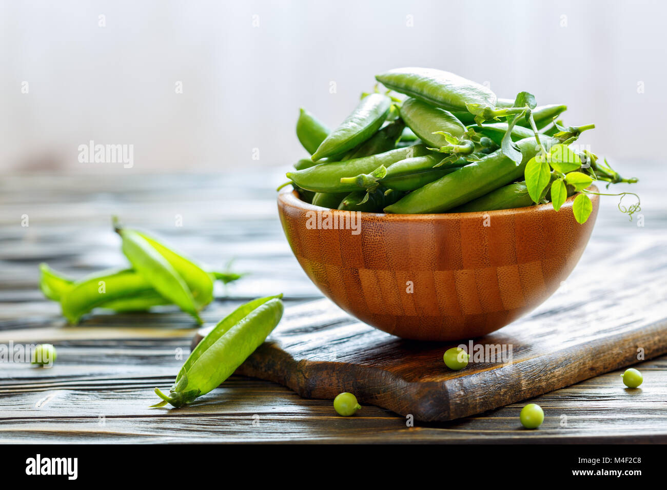 Wooden bowl with green pea pods. Stock Photo