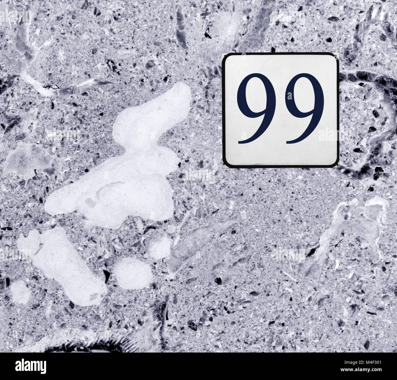 Street number 99 sign on gray-colored marble texture Stock Photo
