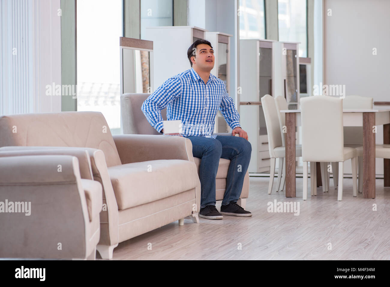 Young man shopping in furniture store Stock Photo - Alamy