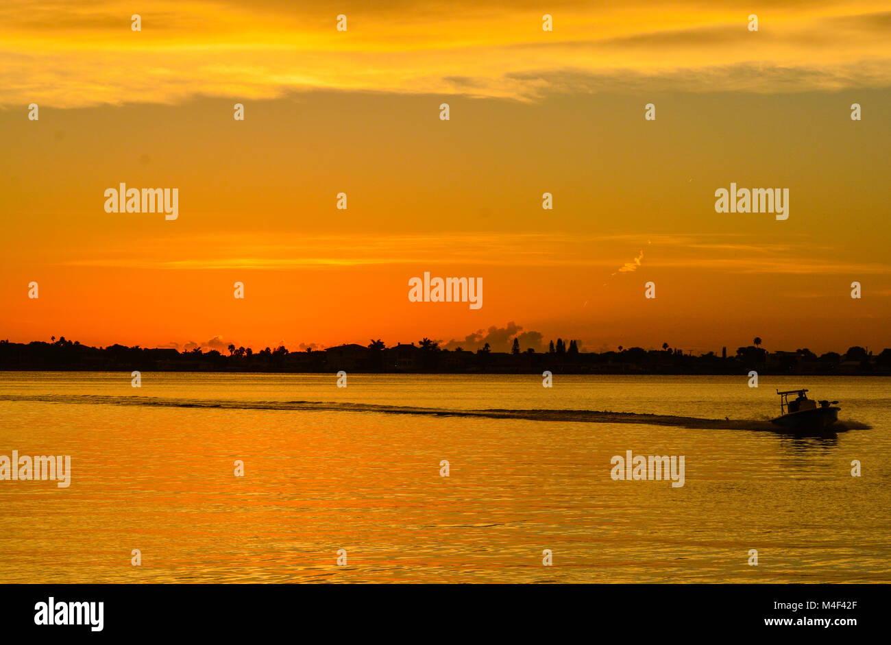 Sunset with the silhouette of a boat Stock Photo - Alamy