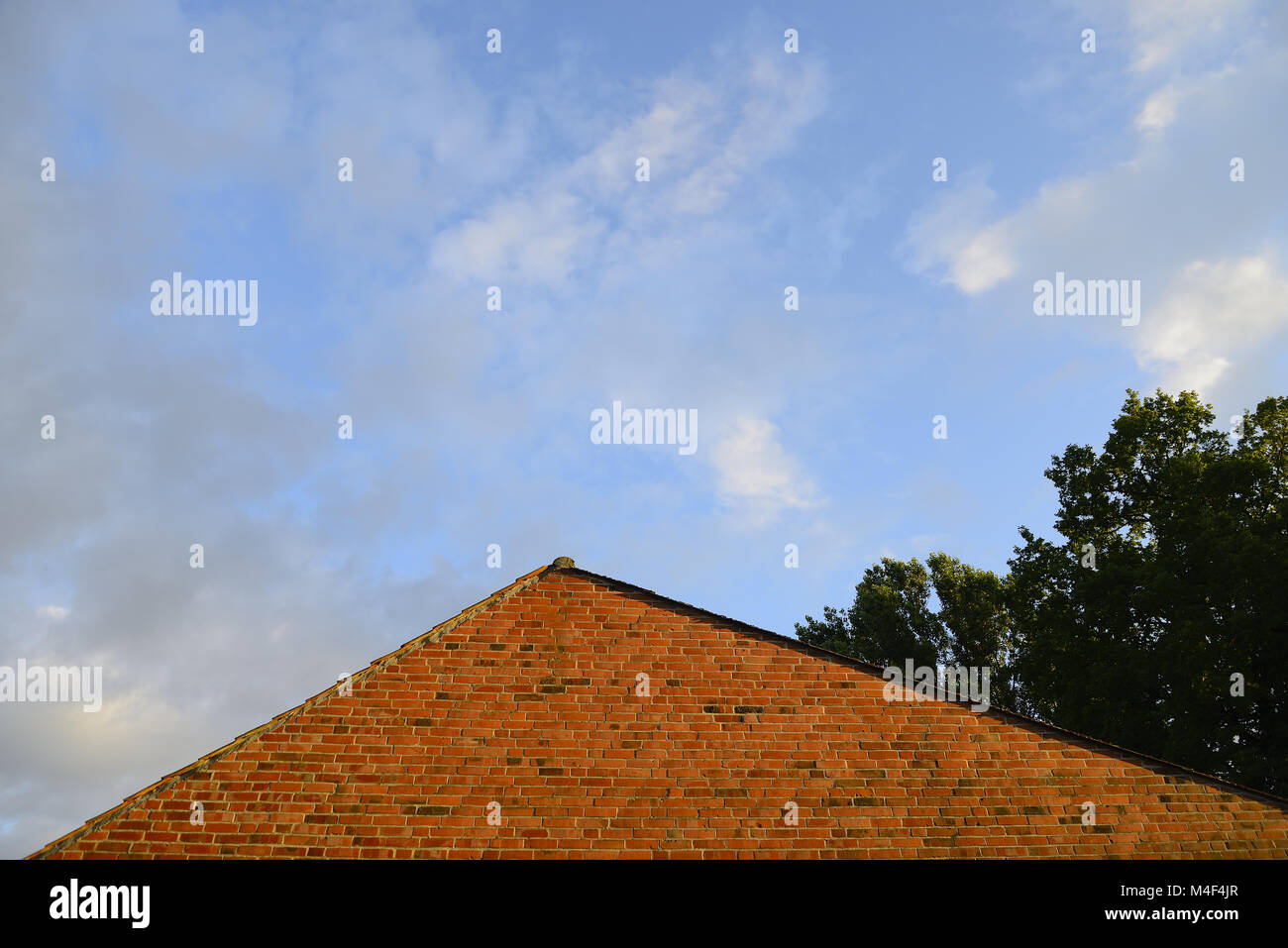 Red brick house wall with sky and clouds, Luechow-Dannenberg district, Wendland: GERMANY, LOWER SAXONY, (c) J.A.Fischer - Gross Wittfeitzen 8 - 29496  Stock Photo