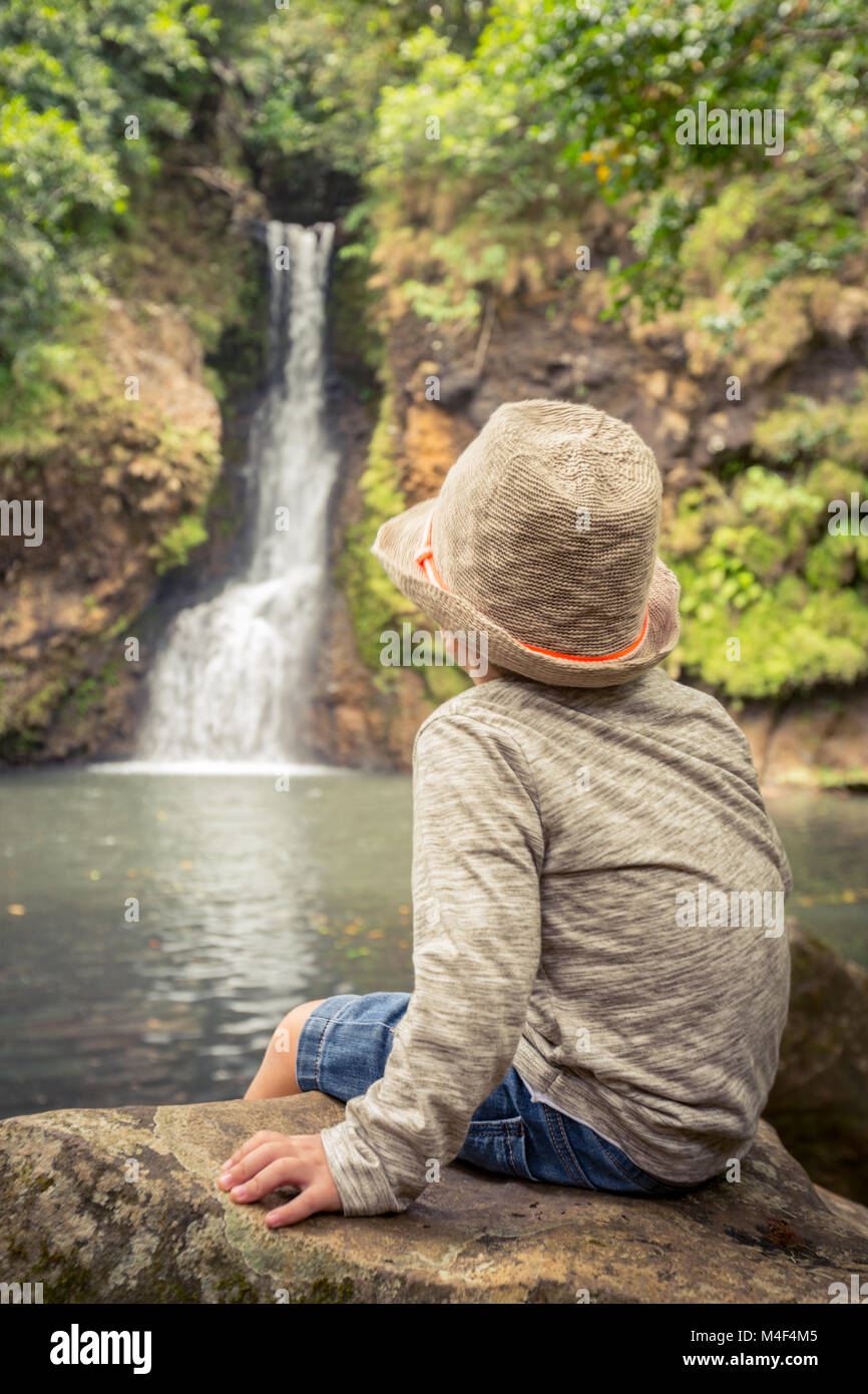 Child looking Chamouze waterfall. Mauritius Stock Photo
