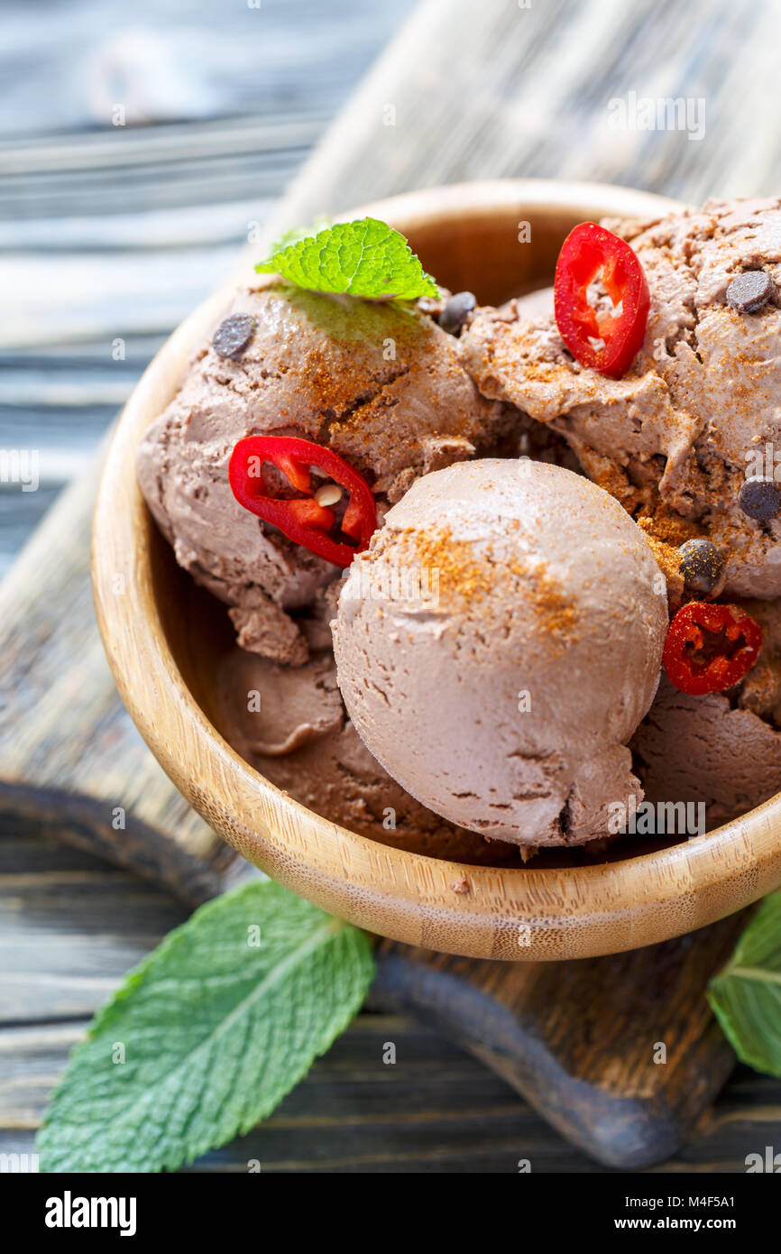 Spicy chocolate ice cream with chilli in a wooden bowl. Stock Photo