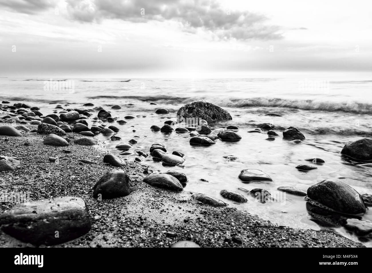 Black and white sea. Waves hitting in rocks Stock Photo