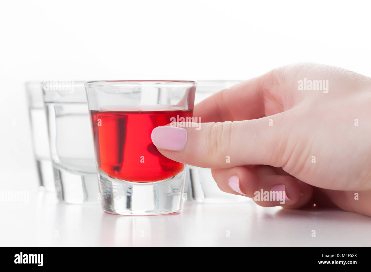 Woman#39;s hand reaching for a glass of alcohol drink. Stock Photo
