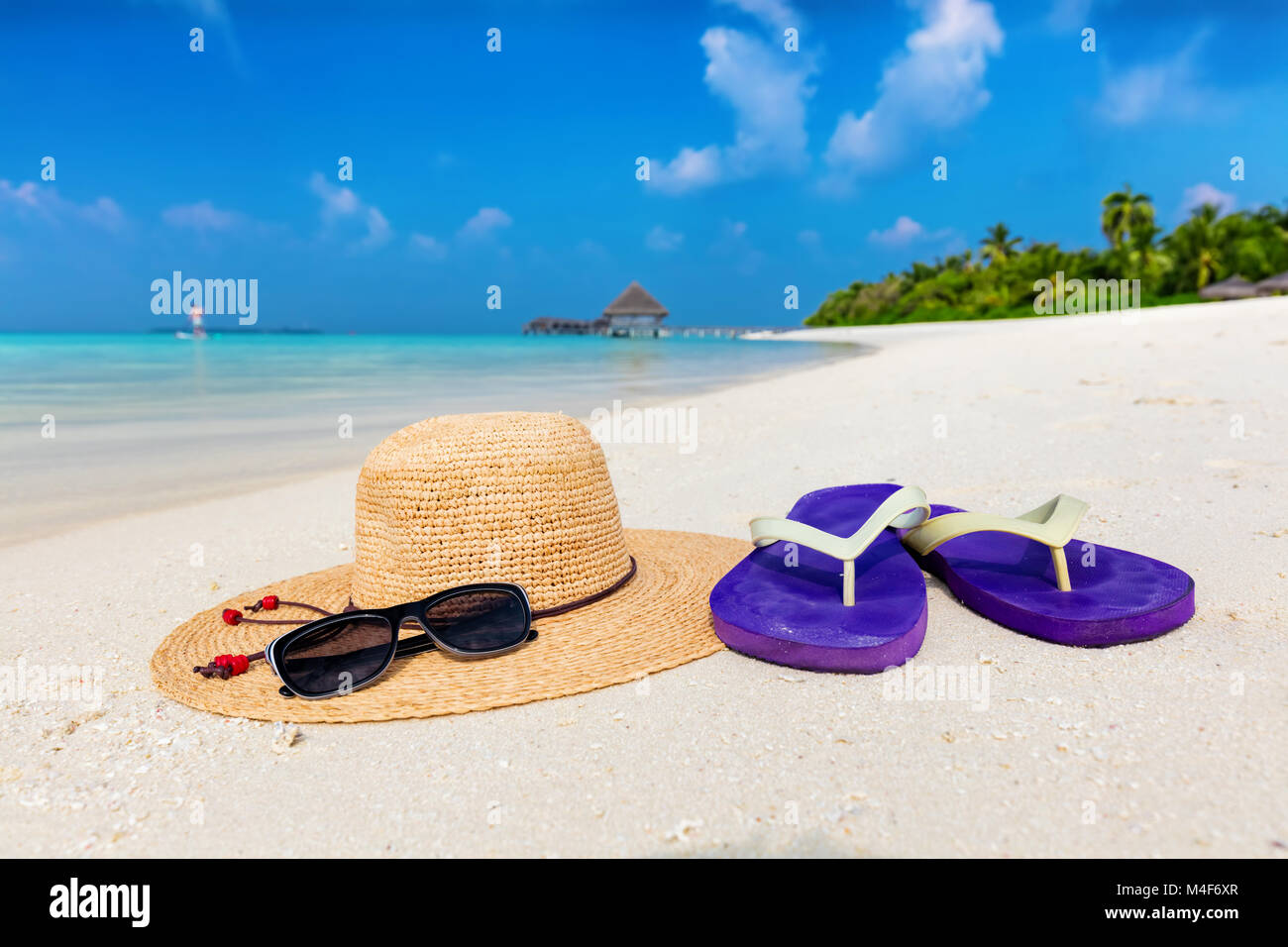 Beach accessories on sand, clear turquoise ocean in Maldives Stock Photo