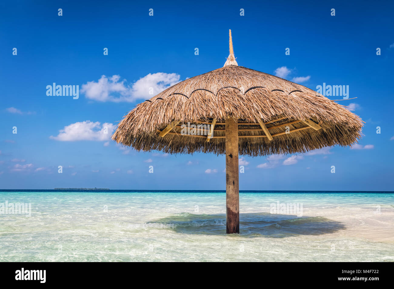 Tropical sandbank island with sunshade umbrella. Indian Ocean, Maldives. Stock Photo