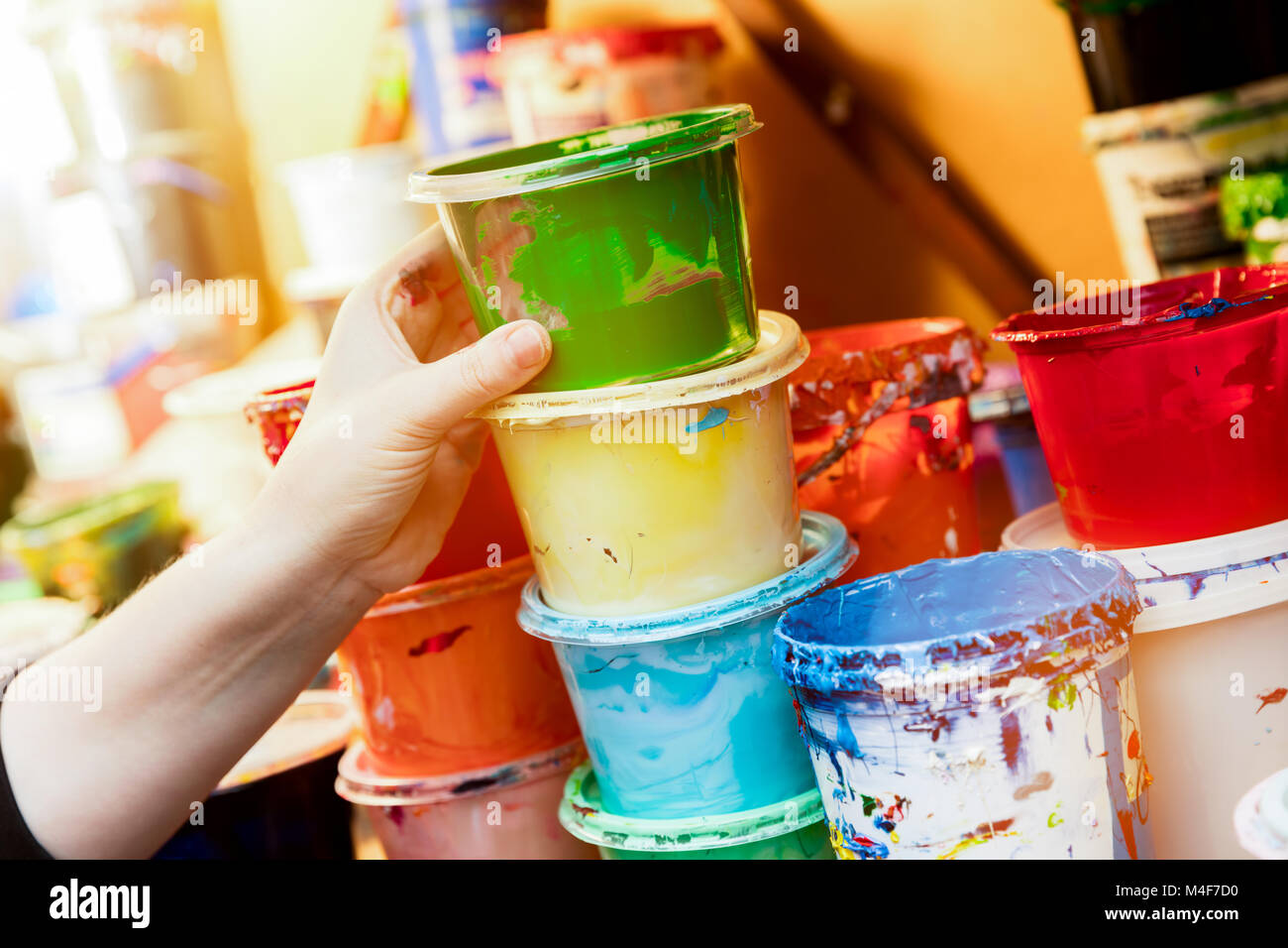 Artist reaching for a liquid paint container. Stock Photo