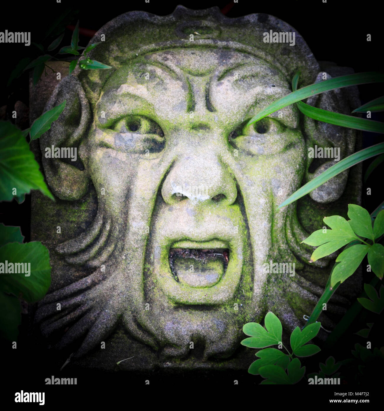 a-variation-on-the-green-man-a-concrete-relief-set-in-a-garden-stock-photo-alamy