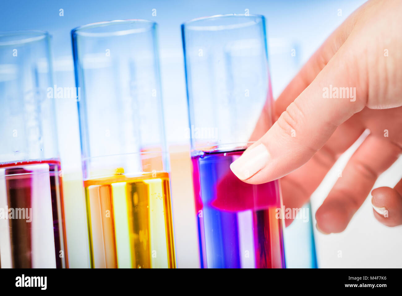 Woman's hand choosing a laboratory testing tube. Stock Photo
