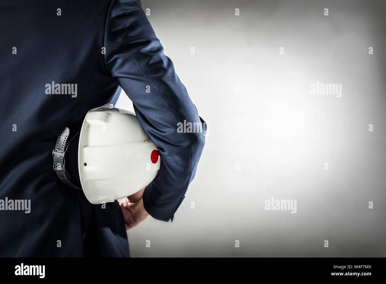Businessman holding white safety helmet. Stock Photo