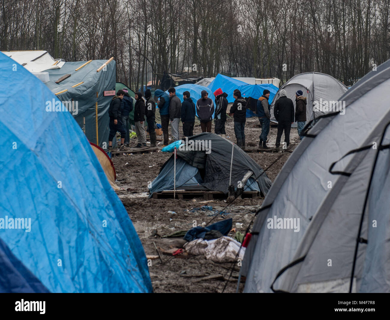 Grande-Synthe, Northern France. 31 January 2016. A General view of the Grande-Synthe refugee camp close to the port of Dunkirk in Northern France. In the camp conditions are grim in part due to thick mud and a lack of basic amenities. Families live in rain soaked tents and huddle around small fires for basic heat. Stock Photo