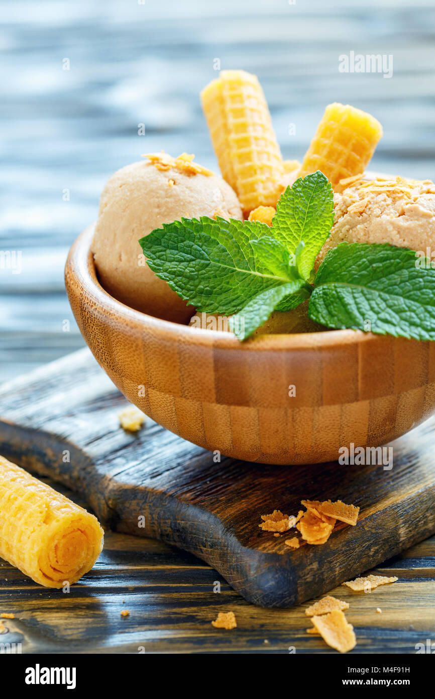 Caramel ice cream and mint leaves in a bowl. Stock Photo