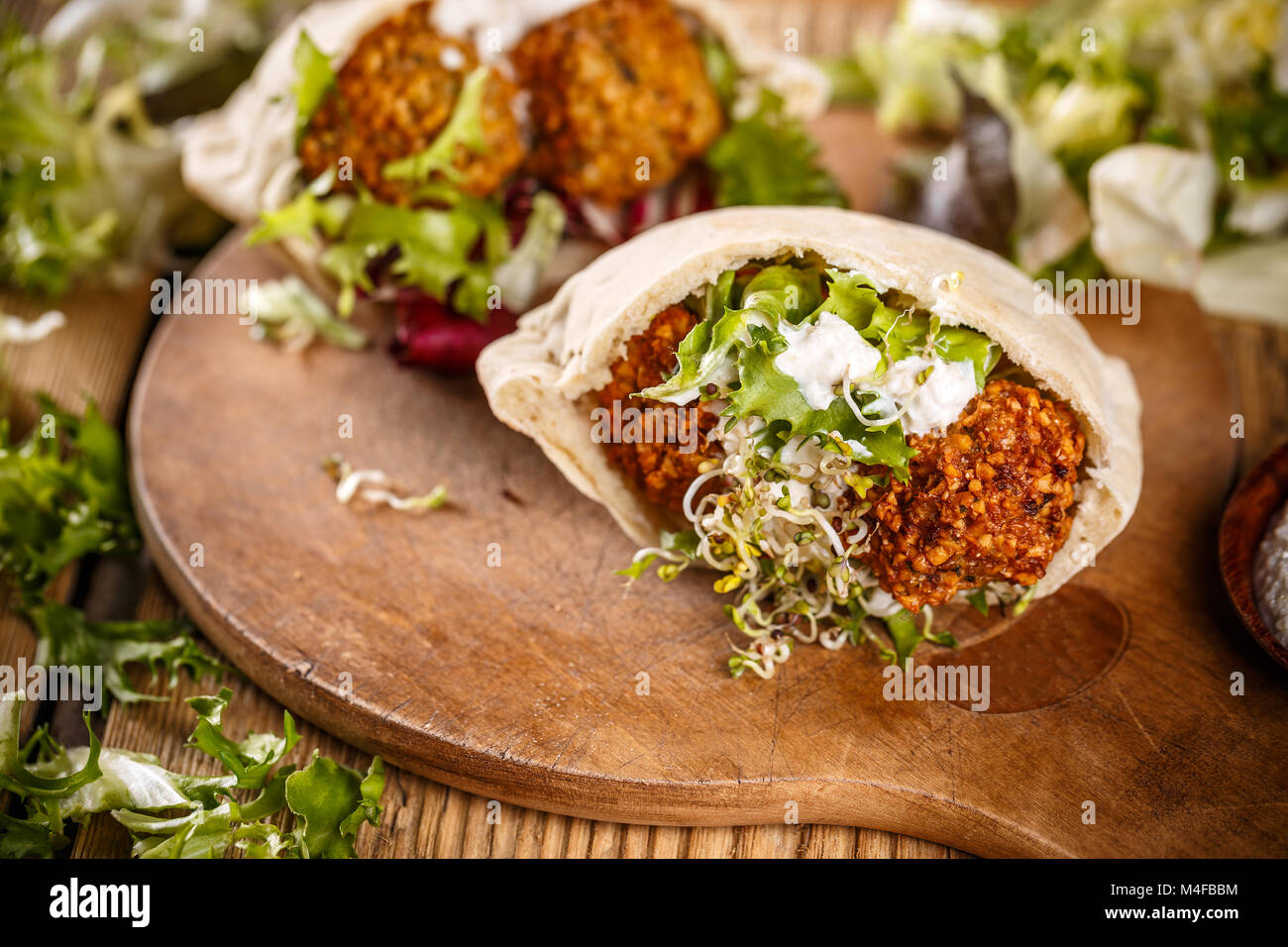 Falafel balls, pita-arabian bread and fresh vegetables on a wooden background Stock Photo