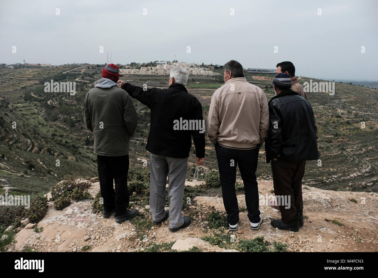 Palestinian landowners which claim back their land taken by Jewish settlers gazing at Rosh Tzurim Jewish settlement located in Gush Etzion a cluster of Jewish settlements in the Judean mountains West Bank Israel Stock Photo
