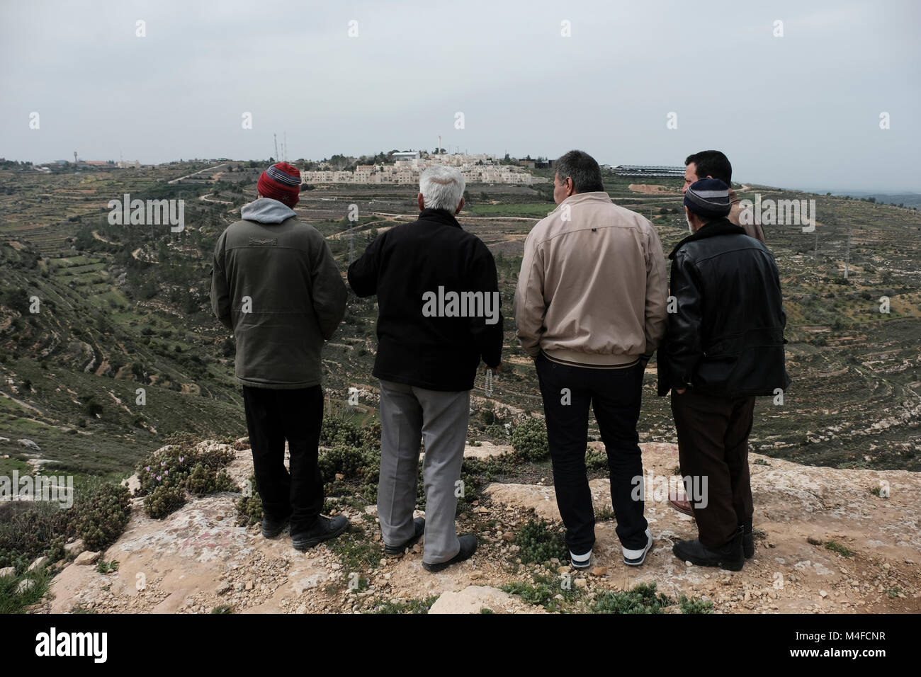 Palestinian landowners which claim back their land taken by Jewish settlers gazing at Rosh Tzurim Jewish settlement located in Gush Etzion a cluster of Jewish settlements in the Judean mountains West Bank Israel Stock Photo