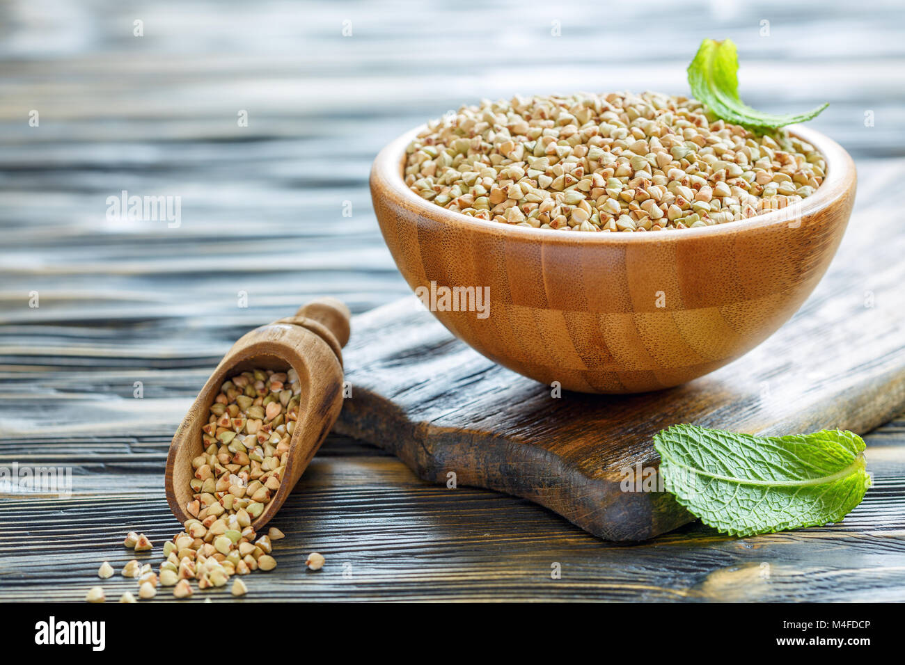 Green buckwheat and wooden scoop. Stock Photo