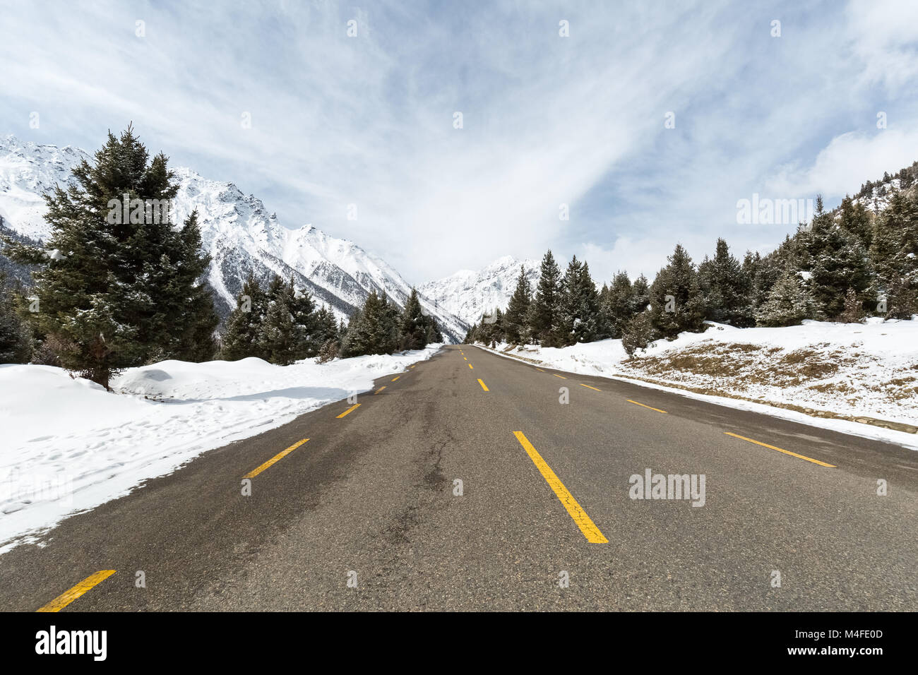 empty asphalt road between the snow mountain Stock Photo