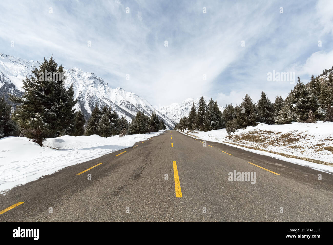 empty asphalt road between the snow mountain Stock Photo