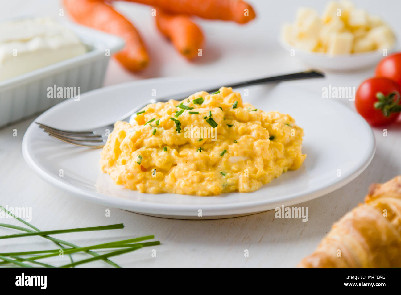 fresh scrambled eggs on white plate on breakfast table Stock Photo - Alamy