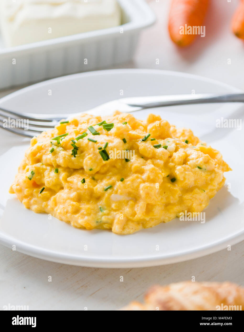 fresh scrambled eggs on white plate on breakfast table Stock Photo - Alamy