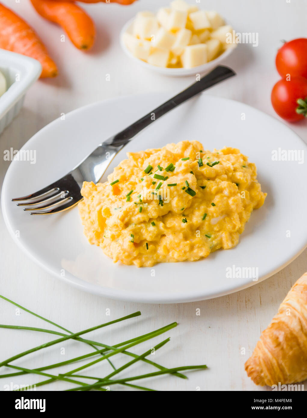 fresh scrambled eggs on white plate on breakfast table Stock Photo - Alamy