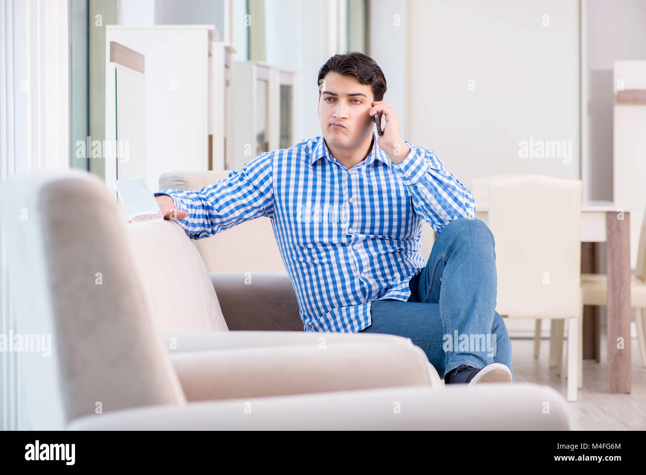 Young man shopping in furniture store Stock Photo - Alamy