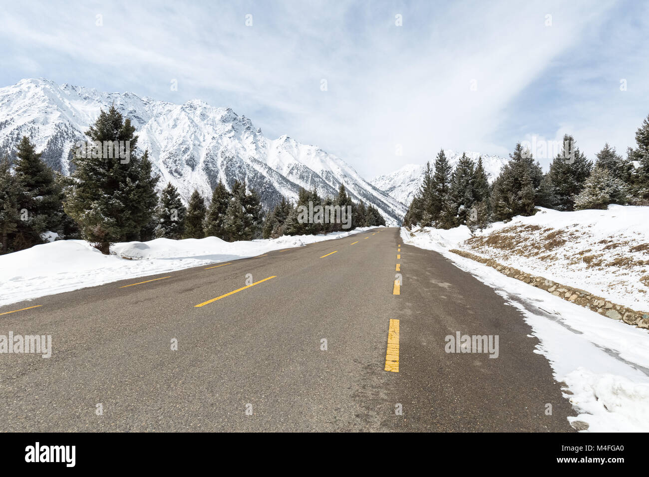 empty asphalt road between the snow mountain Stock Photo
