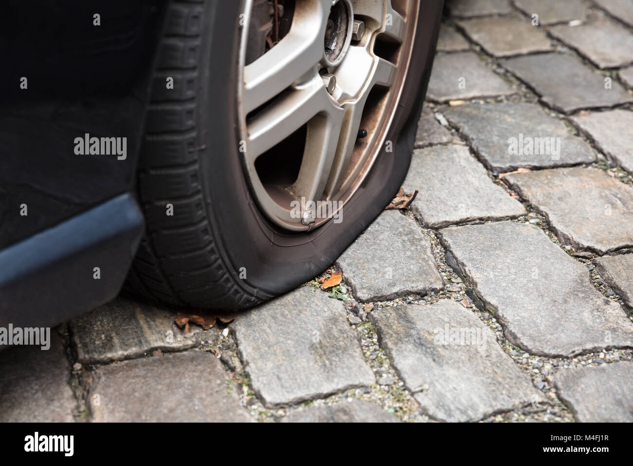Close-up Of A Damaged Flat Tire Of A Car On The Road Stock Photo