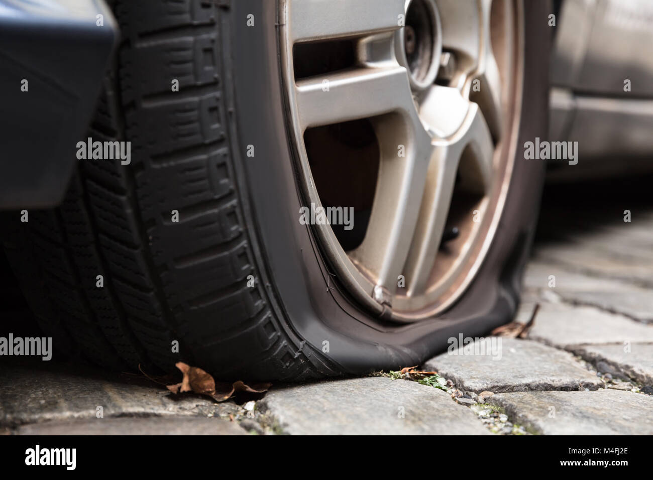 Close-up Of A Damaged Flat Tire Of A Car On The Road Stock Photo