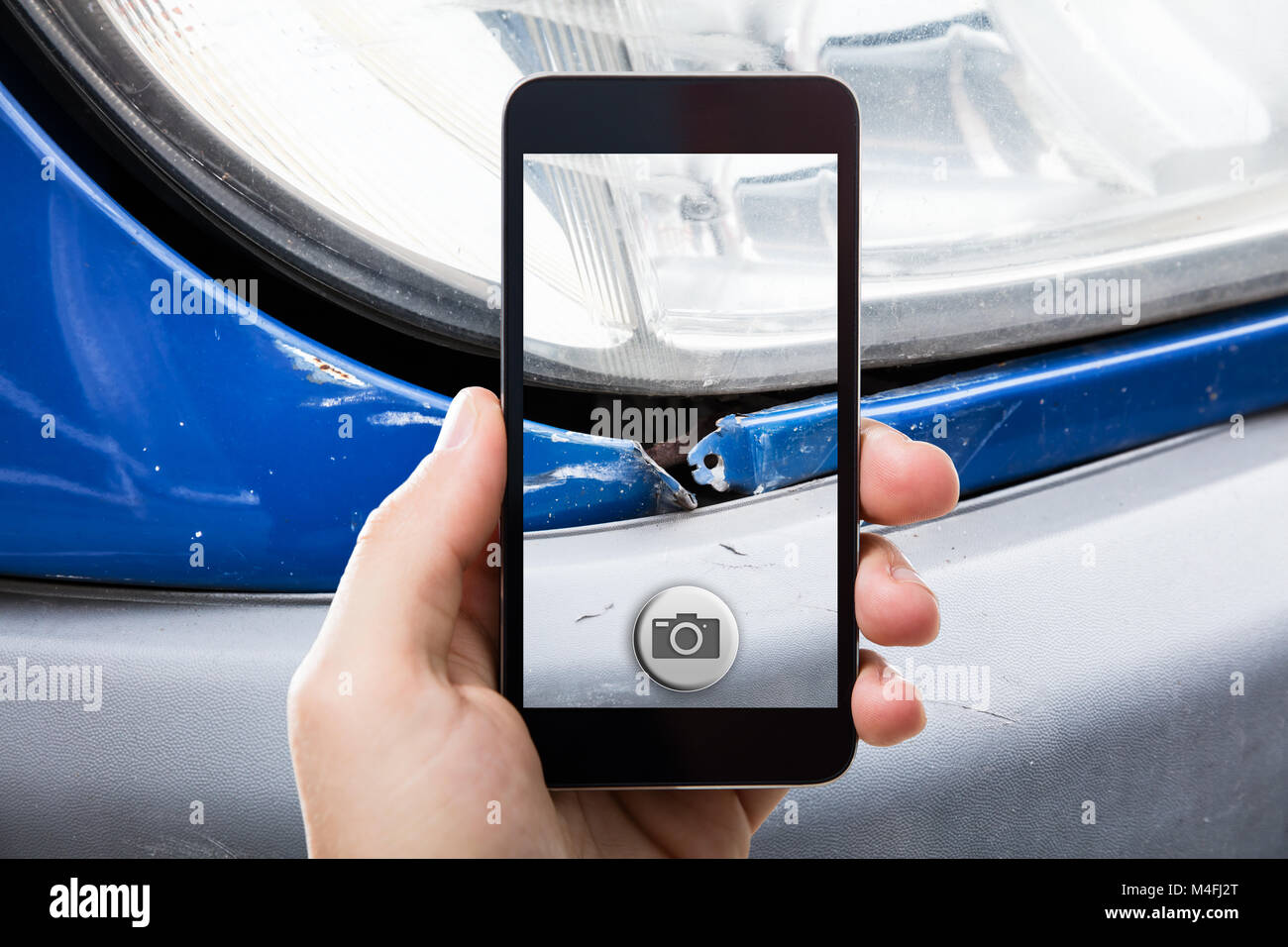 Close-up Of A Person Taking Picture Of A Damaged Car On Mobile Phone Stock Photo