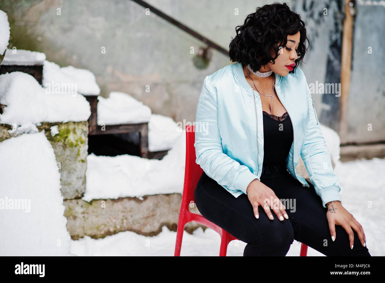 Stylish African American Plus Size Model Sitting On Red Chair
