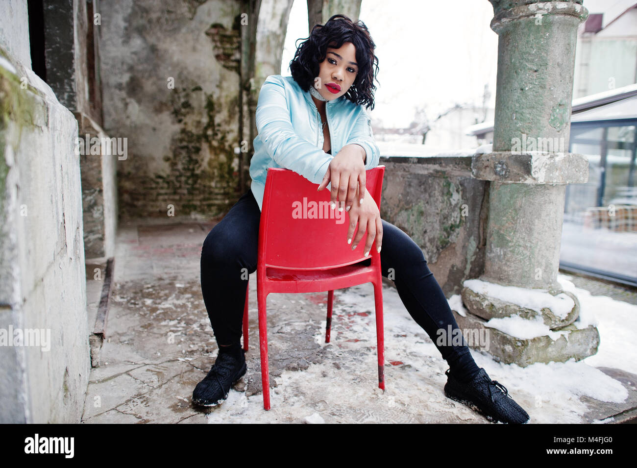 Stylish African American Plus Size Model Sitting On Red Chair